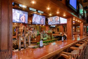 wooden sports bar with multiple tv screens